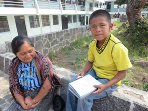 Andres, a student, writes down information as the women cannot read or write